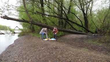 Bir erkek ve bir kadın doğada piknik yaptılar. Doğada aktif eğlence..