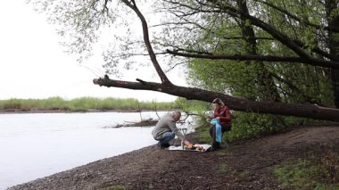 Bir erkek ve bir kadın doğada piknik yaptılar. Doğada aktif eğlence..