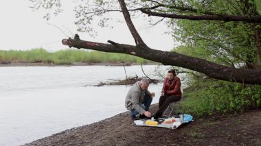 Bir erkek ve bir kadın doğada piknik yaptılar. Doğada aktif eğlence..