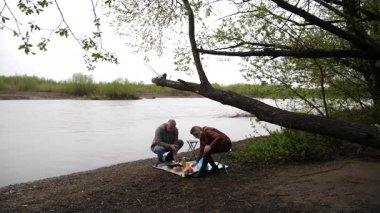 Bir erkek ve bir kadın doğada piknik yaptılar. Doğada aktif eğlence..