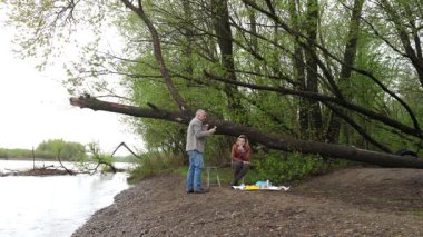 Bir erkek ve bir kadın doğada piknik yaptılar. Doğada aktif eğlence..