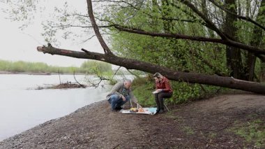 Bir erkek ve bir kadın doğada piknik yaptılar. Doğada aktif eğlence..