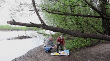 Bir erkek ve bir kadın doğada piknik yaptılar. Doğada aktif eğlence..