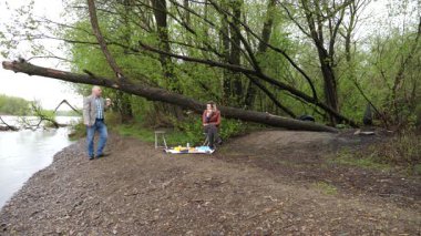 Bir erkek ve bir kadın doğada piknik yaptılar. Doğada aktif eğlence..