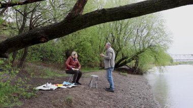 Bir erkek ve bir kadın doğada piknik yaptılar. Doğada aktif eğlence..