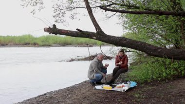 Bir erkek ve bir kadın doğada piknik yaptılar. Doğada aktif eğlence..