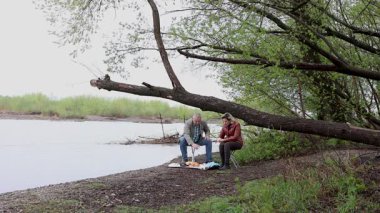 Bir erkek ve bir kadın doğada piknik yaptılar. Doğada aktif eğlence..