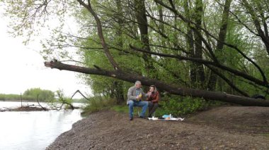 Bir erkek ve bir kadın doğada piknik yaptılar. Doğada aktif eğlence..