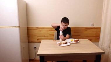 Çocuk kurabiye yiyor ve yoğurt içiyor. Sağlıklı beslenme.