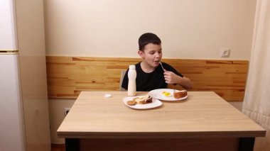 Çocuk kurabiye yiyor ve yoğurt içiyor. Sağlıklı beslenme.