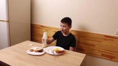 Çocuk kurabiye yiyor ve yoğurt içiyor. Sağlıklı beslenme.