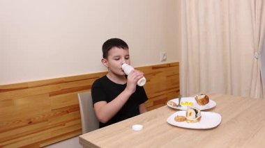 Çocuk kurabiye yiyor ve yoğurt içiyor. Sağlıklı beslenme.