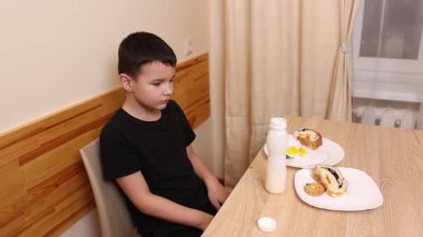 Çocuk kurabiye yiyor ve yoğurt içiyor. Sağlıklı beslenme.