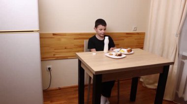 Çocuk kurabiye yiyor ve yoğurt içiyor. Sağlıklı beslenme.