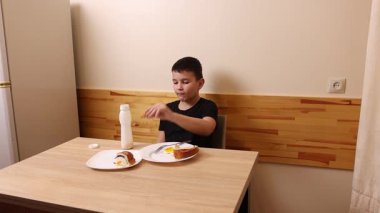 Çocuk kurabiye yiyor ve yoğurt içiyor. Sağlıklı beslenme.