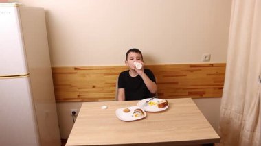 Çocuk kurabiye yiyor ve yoğurt içiyor. Sağlıklı beslenme.