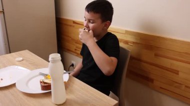 Çocuk kurabiye yiyor ve yoğurt içiyor. Sağlıklı beslenme.