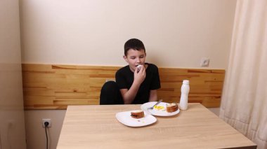 Çocuk kurabiye yiyor ve yoğurt içiyor. Sağlıklı beslenme.