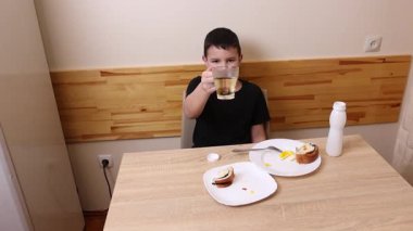 Çocuk kurabiye yiyor ve yoğurt içiyor. Sağlıklı beslenme.