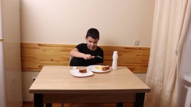 Çocuk kurabiye yiyor ve yoğurt içiyor. Sağlıklı beslenme.