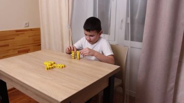Çocuk harflerle küplerle oynuyor. Eğitim süreci.