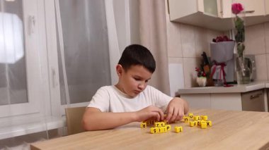 Çocuk harflerle küplerle oynuyor. Eğitim süreci.