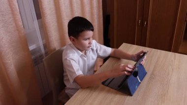 Çocuk tabletle oyun oynuyor. Çalışmak ve dinlenmek..