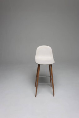 Stüdyo beyaz deri koltuk, arka planda tahta bacaklar..