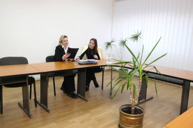 İki kadın iş konuşmak ve sözleşme imzalamak için bir ofiste buluşuyor..