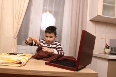 Oğlan çatal ve mutfak bıçaklarını siliyor. Ev işleri..