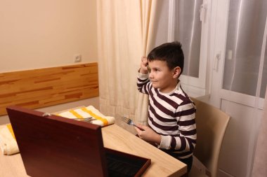 Oğlan çatal ve mutfak bıçaklarını siliyor. Ev işleri..