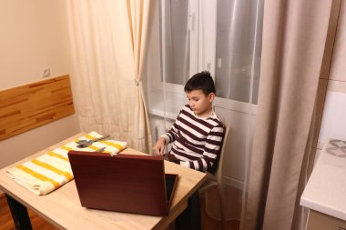 Oğlan çatal ve mutfak bıçaklarını siliyor. Ev işleri..