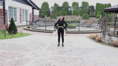 Genç bir kız dışarıda bir dinlenme tesisinde fiziksel egzersiz yapıyor..