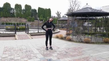 Genç bir kız dışarıda bir dinlenme tesisinde fiziksel egzersiz yapıyor..