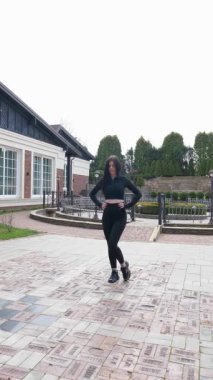 Genç bir kız dışarıda bir dinlenme tesisinde fiziksel egzersiz yapıyor..