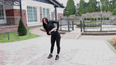 Genç bir kız dışarıda bir dinlenme tesisinde fiziksel egzersiz yapıyor..