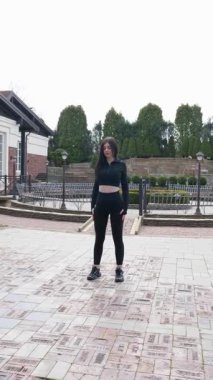 Genç bir kız dışarıda bir dinlenme tesisinde fiziksel egzersiz yapıyor..