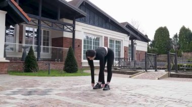 Genç bir kız dışarıda bir dinlenme tesisinde fiziksel egzersiz yapıyor..