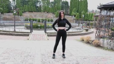 Genç bir kız dışarıda bir dinlenme tesisinde fiziksel egzersiz yapıyor..
