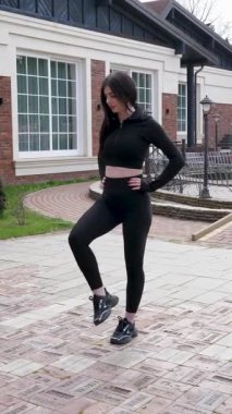 Genç bir kız dışarıda bir dinlenme tesisinde fiziksel egzersiz yapıyor..