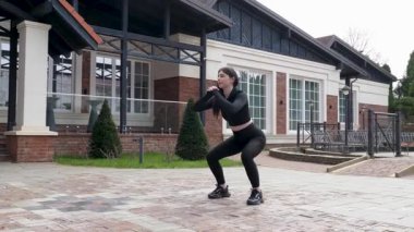 Genç bir kız dışarıda bir dinlenme tesisinde fiziksel egzersiz yapıyor..