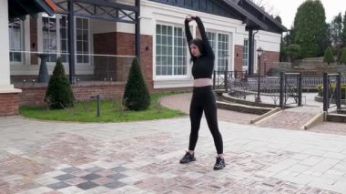 Genç bir kız dışarıda bir dinlenme tesisinde fiziksel egzersiz yapıyor..