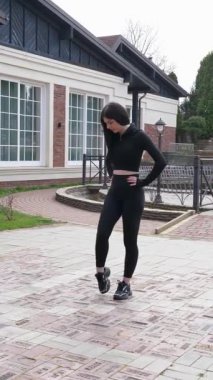 Genç bir kız dışarıda bir dinlenme tesisinde fiziksel egzersiz yapıyor..