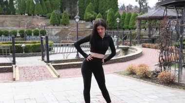 Genç bir kız dışarıda bir dinlenme tesisinde fiziksel egzersiz yapıyor..