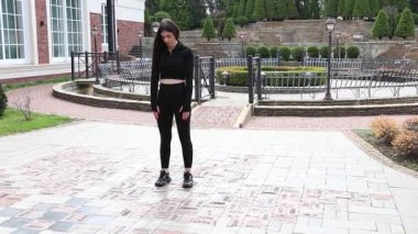 Genç bir kız dışarıda bir dinlenme tesisinde fiziksel egzersiz yapıyor..