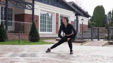 Genç bir kız dışarıda bir dinlenme tesisinde fiziksel egzersiz yapıyor..