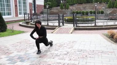 Genç bir kız dışarıda bir dinlenme tesisinde fiziksel egzersiz yapıyor..