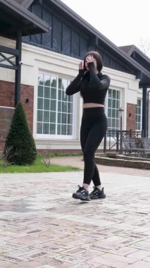 Genç bir kız dışarıda bir dinlenme tesisinde fiziksel egzersiz yapıyor..