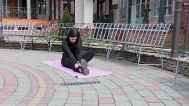 Genç bir kız dışarıda bir dinlenme tesisinde fiziksel egzersiz yapıyor..