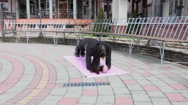 Genç bir kız dışarıda bir dinlenme tesisinde fiziksel egzersiz yapıyor..